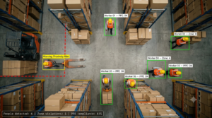 AI video analytics detecting workers, PPE compliance, and zone violations in a warehouse using computer vision